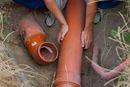 Orange Sewer Pipe Held by hands